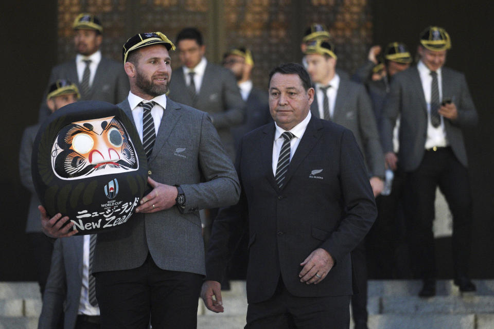 New Zealand All Blacks captain Kieran Read, left, holds a "daruma" or tumbling doll as a good luck charm as All Blacks coach Steve Hansen, right, walks together for a group photo session after the team's welcome ceremony of the Rugby World Cup 2019 at Zojoji temple in Tokyo Saturday, Sept. 14, 2019. Rugby World Cup will start from Sept. 20 in Japan. (AP Photo/Eugene Hoshiko)