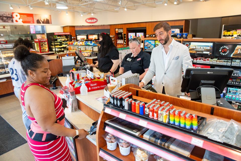 Kum & Go CEO Tanner Krause helps a customer while visiting the store at 1300 Keo Way in Des Moines in 2021.