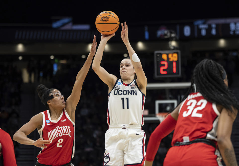 UConn guard Lou Lopez Senechal (11) shoots the ball against Ohio State forward Taylor Thierry (2) and forward Cotie McMahon during the first half of a Sweet 16 college basketball game of the NCAA tournament, Saturday, March 25, 2023, in Seattle. (AP Photo/Stephen Brashear)