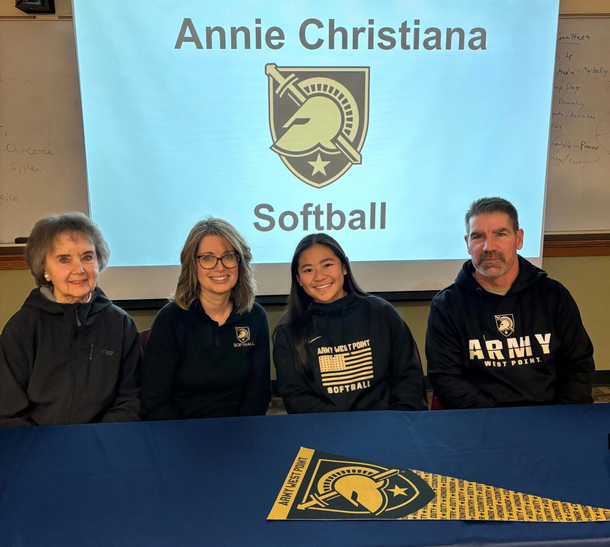 Exeter High School senior Annie Christiana, third from left, sits with her family after signing her commitment to continue her softball and academic careers next fall at the United States Military Academy at West Point.