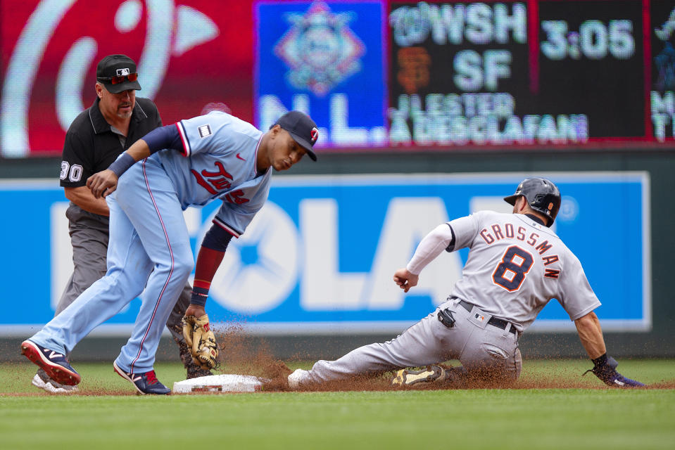 Minnesota Twins shortstop Jorge Polanco (11) is late on a tag of Detroit Tigers left fielder Robbie Grossman (8) slides safely into second base in the first inning of a baseball game, Saturday, July 10, 2021, in Minneapolis. (AP Photo/Andy Clayton-King)