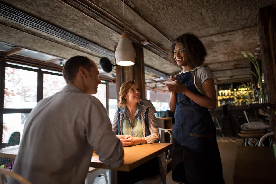 A friendly waiter serving a customer