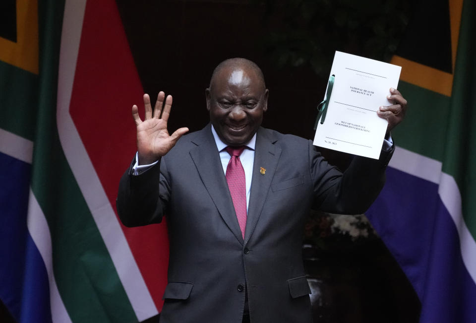 File — South African President Cyril Ramaphosa shows the signed bill for National Health Insurance signed into law in Pretoria, South Africa, Wednesday, May 15, 2024. Today the ruling African National Congress (ANC) faces growing dissatisfaction from many who feel it has failed to live up to its promises. (AP Photo/The,ba Hadebe-File)