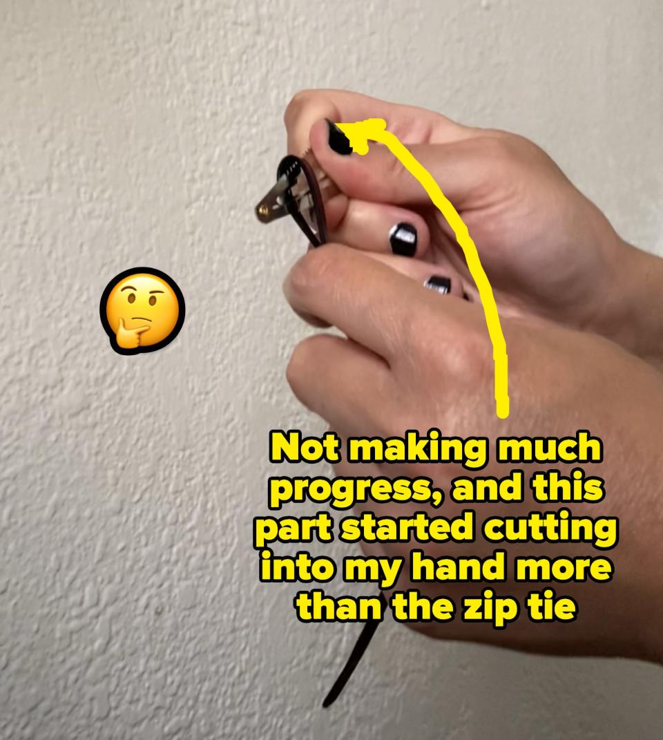 the author bending a zip tie over the edge of the hair clip that has teeth without making much progress in cutting it