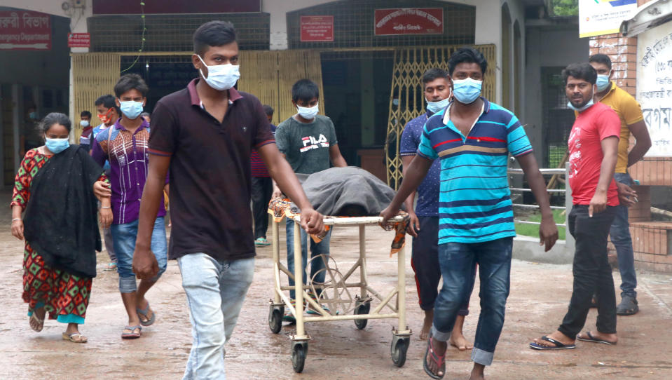 People leave a hospital with the body of a relative at the Medical College Hospital in Rajshahi, 254 kilometers (158 miles) north of the capital, Dhaka, Bangladesh, June 15, 2021. Rajshahi has become one of the latest hotspots for the deadlier delta variant of the coronavirus. Bangladeshi authorities are increasingly becoming worried over the quick spread of coronavirus in about two dozen border districts close to India amid concern that the virus could devastate the crowded nation in coming weeks. (AP Photo/ Kabir Tuhin)