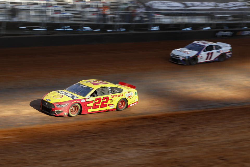 Driver Joey Logano (22) leads Denny Hamlin (11) through Turn 4 during an NASCAR Cup Series auto race, Monday, March 29, 2021, in Bristol, Tenn. (AP Photo/Wade Payne)