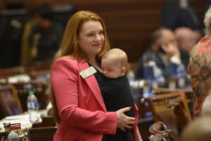  Georgia Republican Rep. Lauren Daniel, holding her son Zane, on the House floor. (Ross Williams/Georgia Recorder)