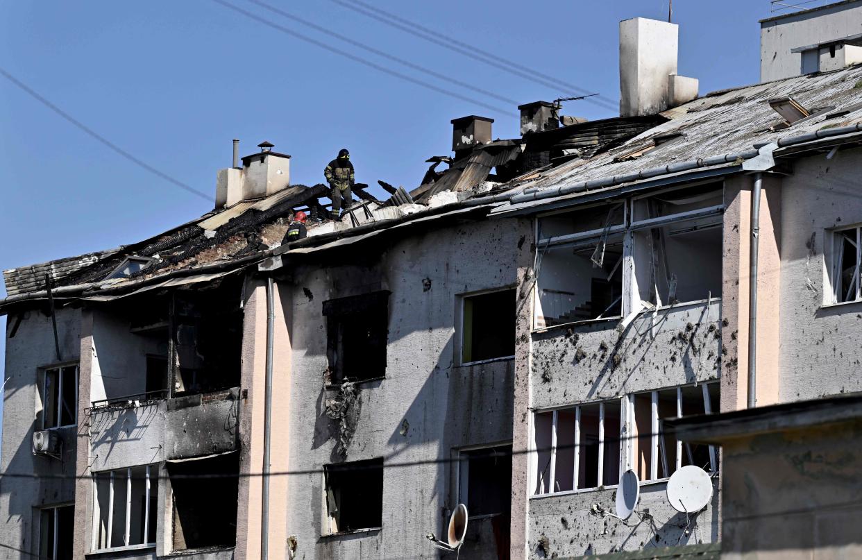 A rescuer examines a roof of a damaged residential building after missile strike on the city of Lviv (AFP via Getty Images)