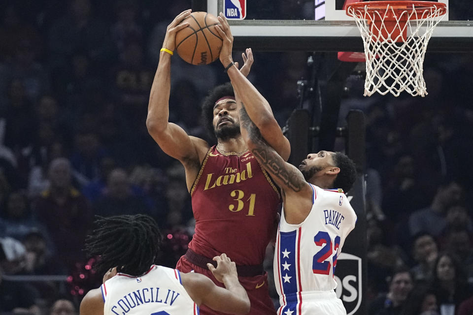 Cleveland Cavaliers center Jarrett Allen (31) grabs a pass in front of Philadelphia 76ers guards Ricky Council IV, left, and Cameron Payne (22) in the first half of an NBA basketball game, Monday, Feb. 12, 2024, in Cleveland. (AP Photo/Sue Ogrocki)