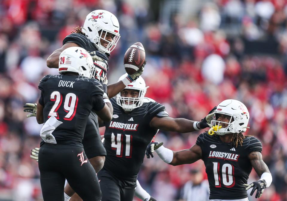Louisville Cardinals linebacker TJ Quinn (34) holding the ball celebrates after making an interception which helped put UofL in scoring position as the Cards rolled past Virginia Tech 34-3 Saturday. Nov.4, 2023.