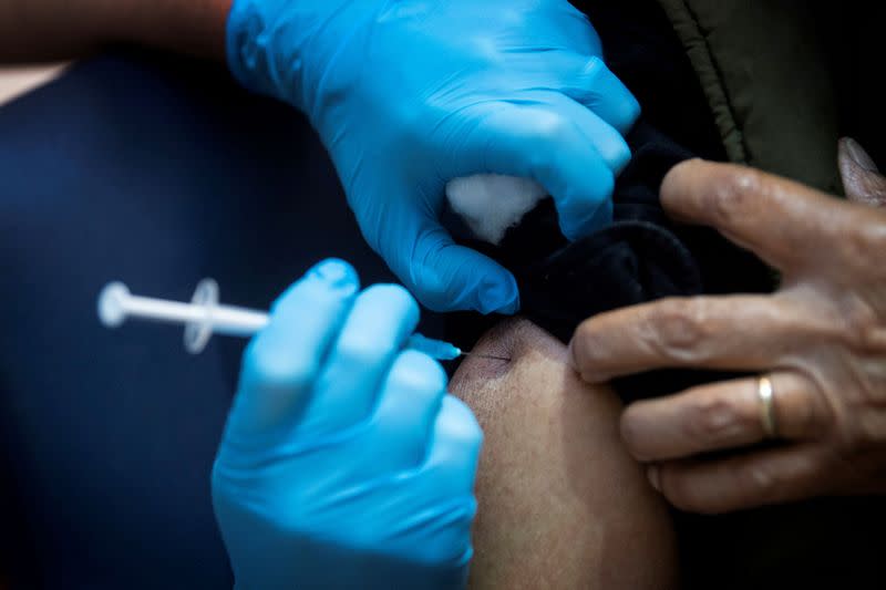 FILE PHOTO: A man receives the first of two Pfizer/BioNTech COVID-19 vaccine jabs, at Guy's Hospital in London