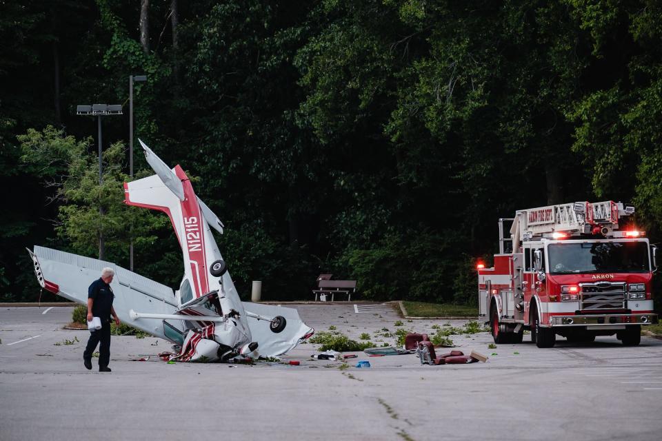 Akron Firefighters work the scene of a plane crash where a single-piston Cessna Skyhawk went down at Ellet Community Center, Monday, July 4 in Akron.