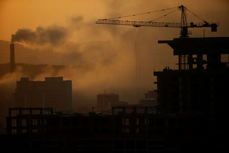 People work atop a building under construction as sun sets in Pyongyang, North Korea April 12, 2017. REUTERS/Damir Sagolj