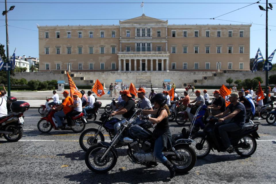 Municipal worker drive their motorcycles during a protest against the new austerity measures outside the Parliament in Athens, on Wednesday, Oct. 3, 2012. The country's budget includes about euros 7.8 billion worth of austerity measures for next year. They are part of a euro13.5 billion package of spending cuts and tax hikes for 2013 and 2014 that Greece's international creditors have demanded in exchange for continued payout of the rescue loans that are protecting the country from a messy default. (AP Photo/Petros Giannakouris)