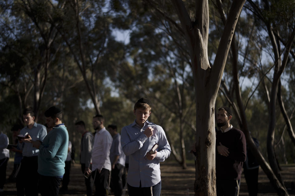 A young Jewish man prays as he visits the site where revelers were killed and kidnapped during the Oct. 7 cross-border attack by Hamas militants at the Nova music festival near Kibbutz Reim, southern Israel, Tuesday, March 5, 2024. (AP Photo/Leo Correa)