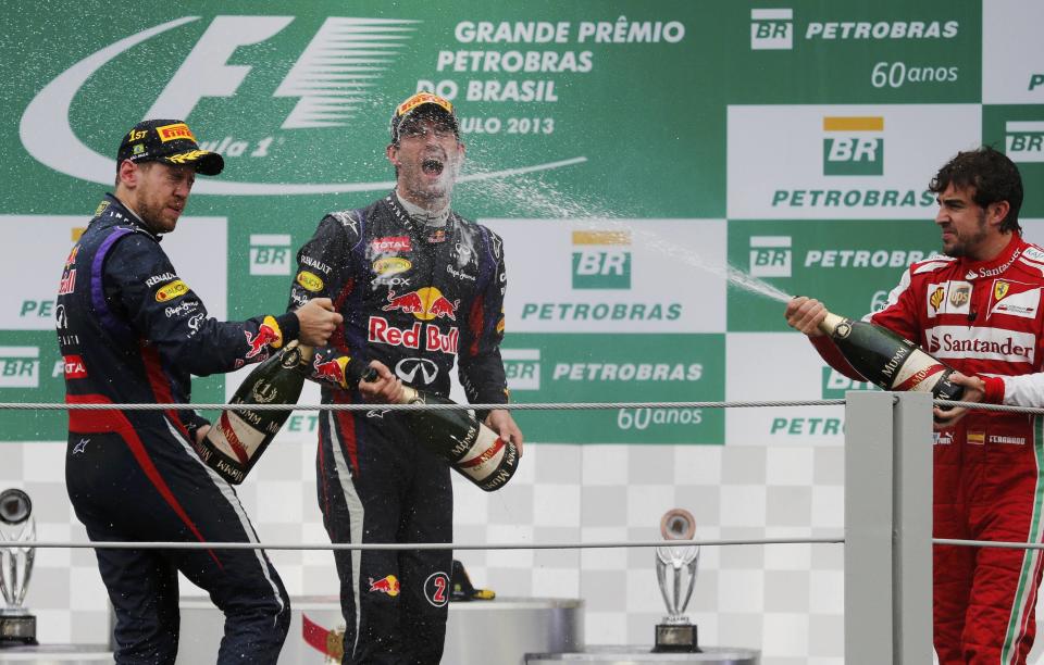 Sebastian Vettel of Germany, Mark Webber of Australia and Fernando Alonso of Spain spray champagne as they celebrate on the podium after the Brazilian F1 Grand Prix at the Interlagos circuit in Sao Paulo