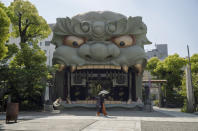 A woman wearing a face mask to help curb the spread of the coronavirus visits the Namba Yasaka Shrine in Osaka, western Japan, Tuesday, April 20, 2021. (AP Photo/Hiro Komae)