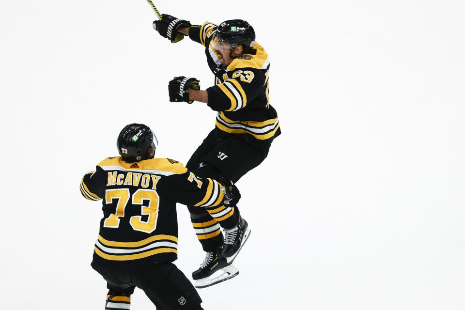 Boston Bruins' Brad Marchand jumps while celebrating his tying goal with teammate Charlie McAvoy in the third period of Game 2 during an NHL hockey second-round playoff series against the New York Islanders, Monday, May 31, 2021, in Boston. (AP Photo/Winslow Townson)