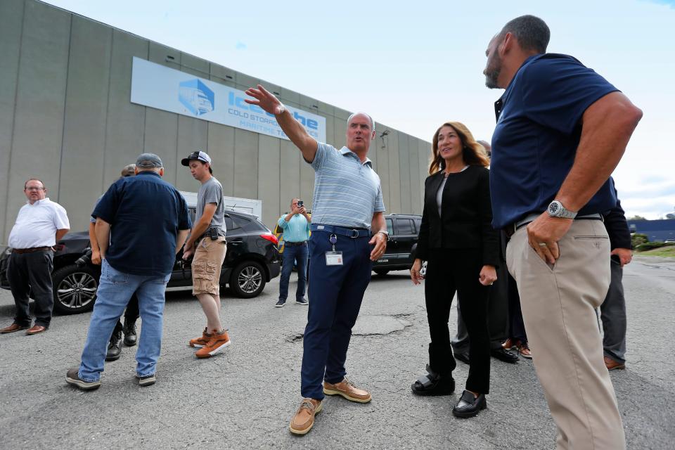 Jason Hutchens, president of Ice Cube Cold Storage & Logistics and his brother Scott Hutchens, vice president, speak with Lt. Governor Karyn Polito during an announcement of the awarding of an Industrial Rail Access Program grant of $361,669 to Ice Cube Maritime in New Bedford.