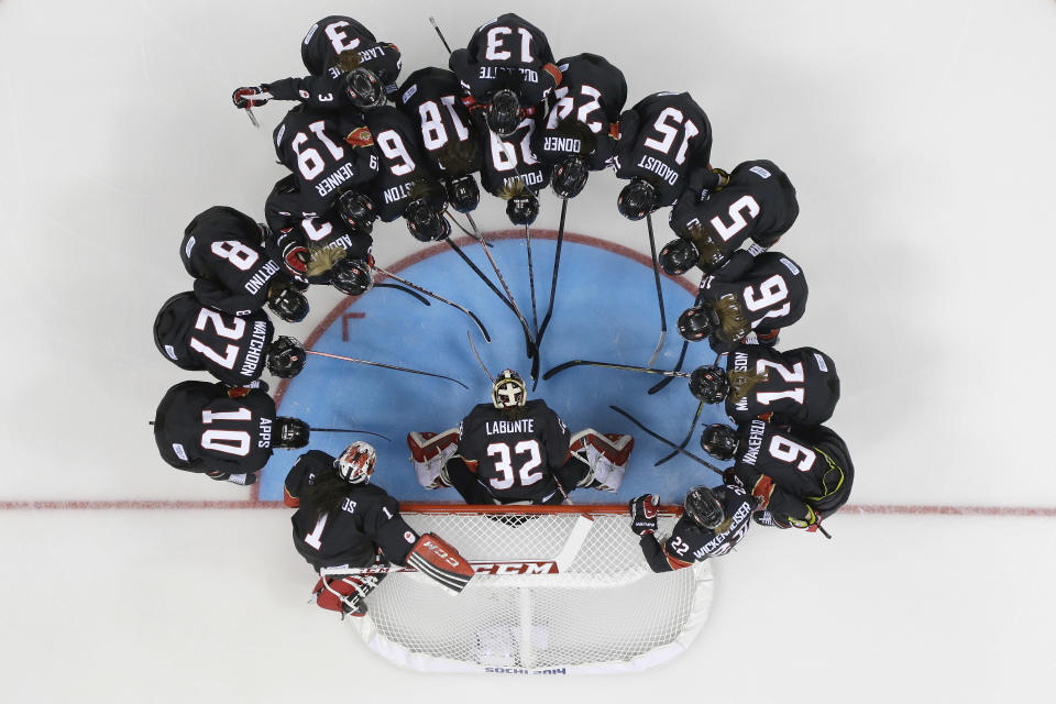 Team Canada huddles before their women's ice hockey game at the Shayba Arena against Switzerland during the 2014 Winter Olympics, Saturday, Feb. 8, 2014, in Sochi, Russia. (AP Photo/Matt Slocum )