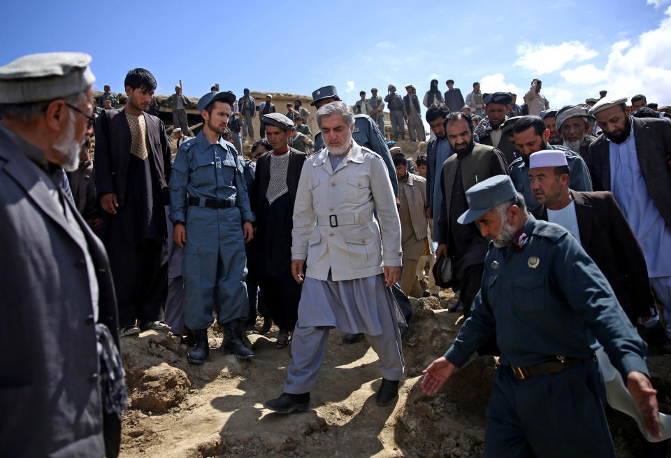 Afghan presidential candidate Abdullah Abdullah, center, visits the site of Friday's landslide that buried Abi-Barik village in Badakhshan province, northeastern Afghanistan, Tuesday, May 6, 2014. As Afghans observed a day of mourning Sunday for the hundreds of people killed in a horrific landslide, authorities tried to help the 700 families displaced by the torrent of mud that swept through their village. (AP Photo/Massoud Hossaini)