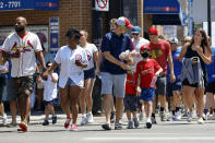 People cross a street as they make their way towards Chicago's Wrigley Field during baseball game, Friday, June 11, 2021, as Chicago and rest of Illinois fully reopens ending an over a year-long COVID-19 restrictions. (AP Photo/Shafkat Anowar)