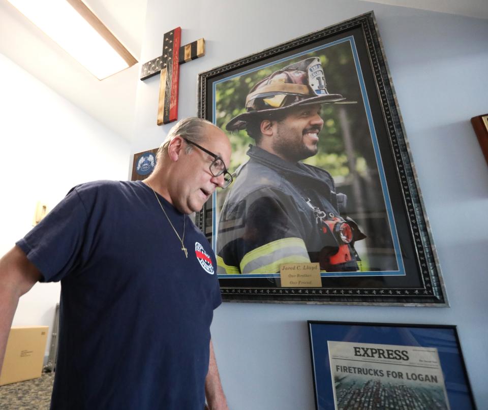 Spring Valley firefighter John Kapral walks past a photo of Jared Lloyd at the Columbian Fire Engine Co. No. 1 firehouse June 22, 2023. Firefighters there, and around the county, are upset about Rockland DA Thomas Walsh's decision to offer a no-jail plea deal to two rabbis whose actions sparked the Evergreen Court fire that killed Lloyd.