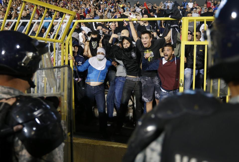 Fans of Serbia confront the riot police during the Euro 2016 Group I qualifying soccer match between Serbia and Albania at the FK Partizan stadium in Belgrade in this October 14, 2014 file photo. REUTERS/Marko Djurica/Files (SERBIA - Tags: TPX IMAGES OF THE DAY SPORT) SOCCER)