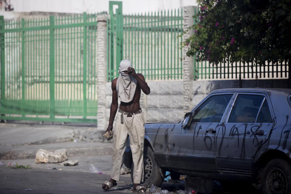 A protester holds a rock during a protest to demand the resignation of President Jovenel Moise and demanding to know how Petro Caribe funds have been used by the current and past administrations, in Port-au-Prince, Haiti, Saturday, Feb. 9, 2019. Much of the financial support to help Haiti rebuild after the 2010 earthquake comes from Venezuela's Petro Caribe fund, a 2005 pact that gives suppliers below-market financing for oil and is under the control of the central government. (AP Photo/Dieu Nalio Chery)