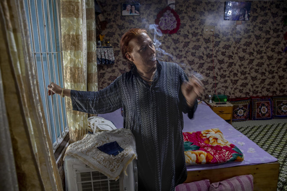 Rinki Ahmed, a transgender Kashmiri, smokes while posing for a photograph at home in Srinagar, Indian controlled Kashmir, Thursday, June 3, 2021. Rinki, who worked as a model in Mumbai when younger, returned to Kashmir and became a matchmaker. "In Kashmiri we have seen a lot of bad times due to the conflict but that never stopped me from going out. But this time nobody lets us inside their homes. I don’t blame them as I am scared myself," Rinki said. (AP Photo/Dar Yasin)