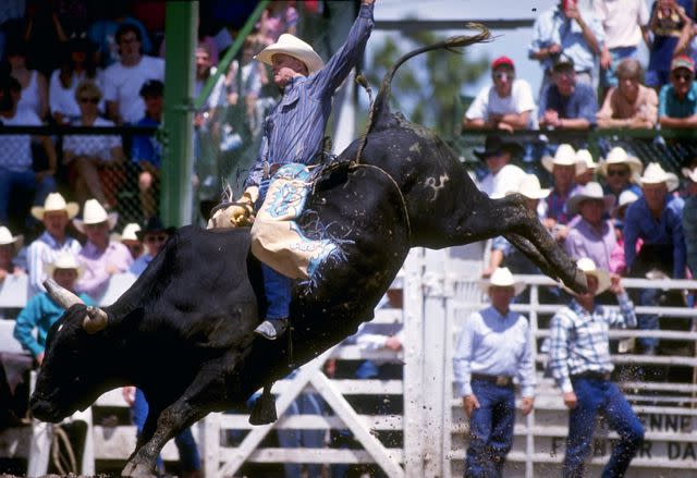 <p>Ken Levine/Allsport/Getty</p> Ty Murray rides a bull during the Cheyenne Frontier Day Rodeo in Cheyenne, Wyoming.
