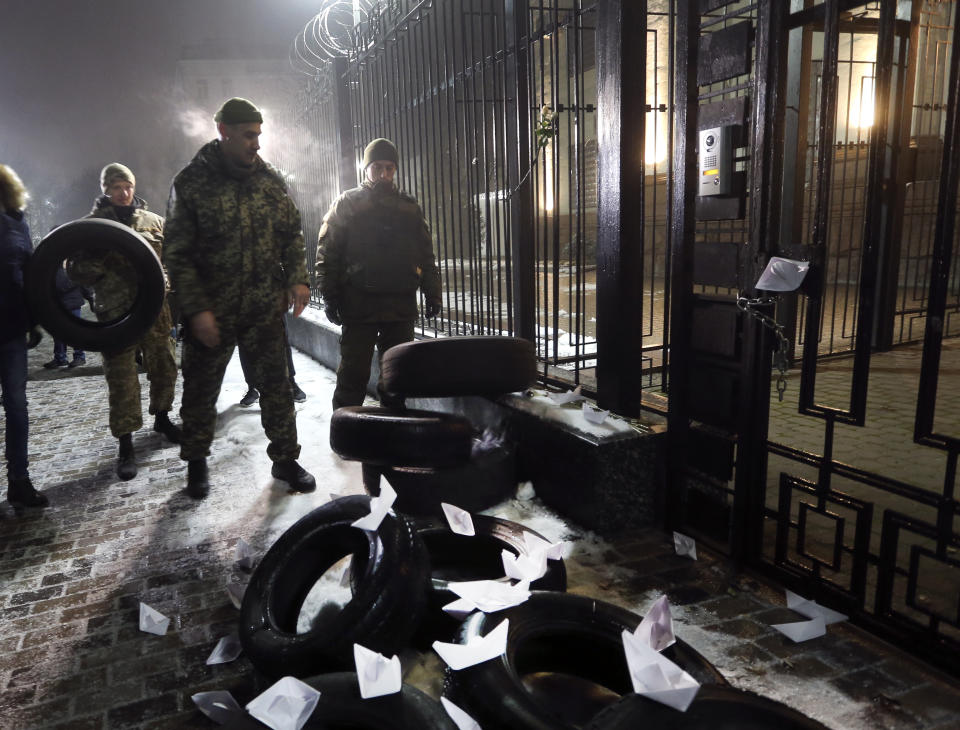 Former Ukrainian soldiers bring tires during their rally in front of the embassy of Russia in Kiev, Ukraine, Sunday, Nov. 25, 2018. Russia's coast guard opened fire on and seized three of Ukraine's vessels Sunday, wounding a few crew members, after a tense standoff in the Black Sea near the Crimean Peninsula, the Ukrainian navy said. (AP Photo/Efrem Lukatsky)