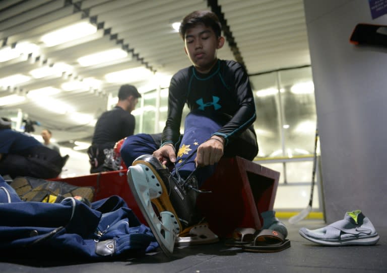 Members of the Philippines men's ice hockey team, dubbed the "Mighty Ducks", prepare their gear prior to a practice session at a mall skating rink in Manila