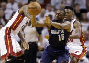 Charlotte Bobcats' Kemba Walker (15) passes the ball as Miami Heat's Norris Cole, right, and another player defend during the first half in Game 2 of an opening-round NBA basketball playoff series, Wednesday, April 23, 2014, in Miami. (AP Photo/Lynne Sladky)