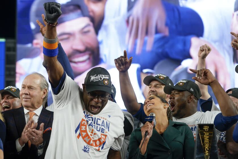 Houston Astros manager Dusty Baker Jr. left, celebrates with the team on the field after defeating the New York Yankees