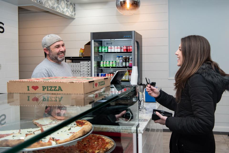 Joe Guardino, manager at Lucatelli's Pizzeria in Doylestown, greets Megan Weiler, of Doylestown, as she picks up a takeout order on Monday, January 24, 2022.