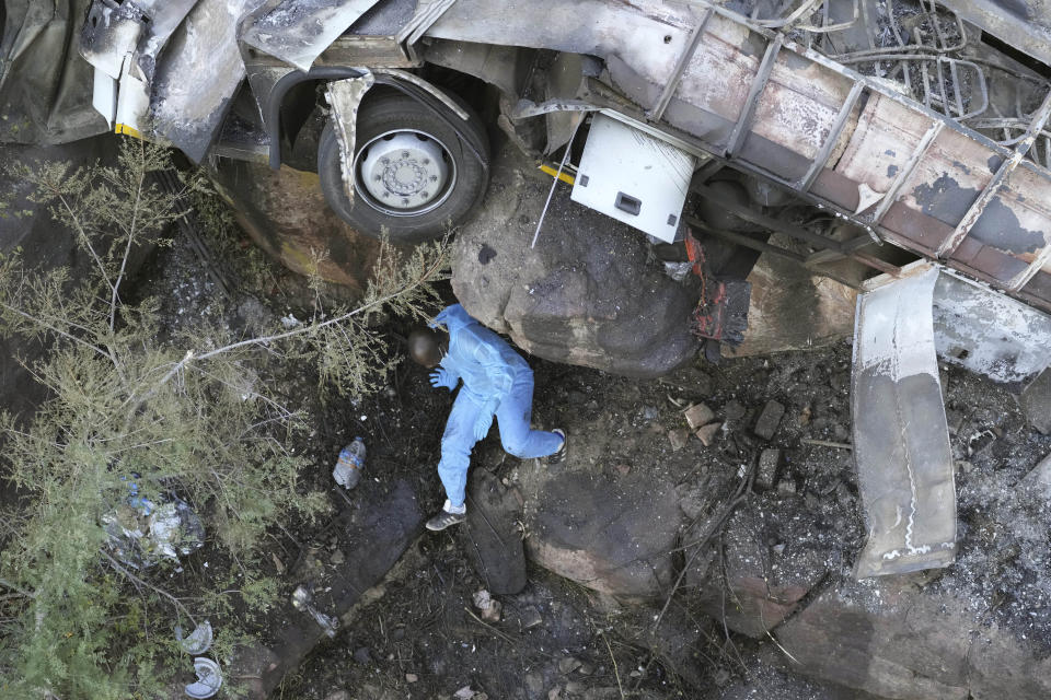 The wreckage off a bus lays in a ravine a day after it plunged off a bridge on the Mmamatlakala mountain pass between Mokopane and Marken, around 300km (190 miles) north of Johannesburg, South Africa, Friday, March 29, 2024. A bus carrying worshippers on a long-distance trip from Botswana to an Easter weekend church gathering in South Africa plunged off a bridge on a mountain pass Thursday and burst into flames as it hit the rocky ground below, killing at least 45 people, authorities said. The only survivor was an 8-year-old child who was receiving medical attention for serious injuries. (AP Photo/Themba Hadebe)