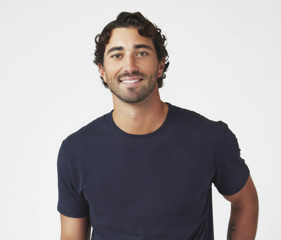 Joey Graziadei smiles in a blue crew neck tshirt against a white background. (Ricky Middlesworth / ABC)