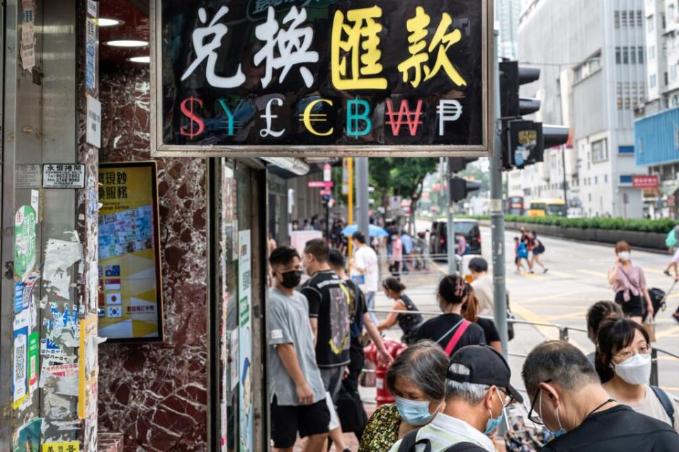 Pedestrians walk past a currency money exchange shop in Hong Kong with a sign offering: US Dollar ($), Japanese Yen (¥), British Pound (£), Euro (), Bitcoin (BTC, BCH), Korean Won (), and Cuba Peso (), September 19, 2022. (Credit: Sebastian Ng/SOPA Images/LightRocket via Getty Images)