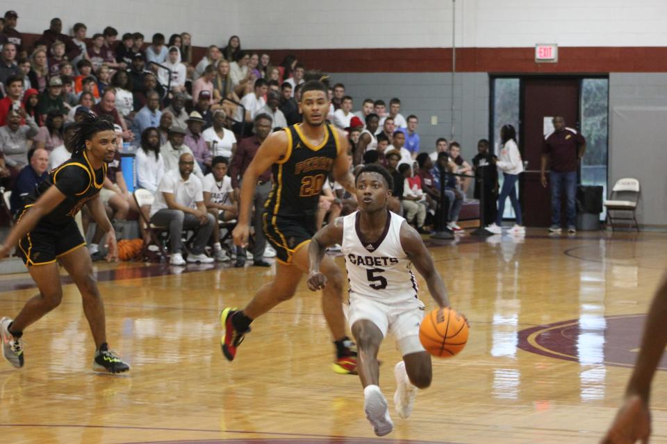 Benedictine's Stephon Frazier drives to the basket in a playoff win over Perry on Saturday.