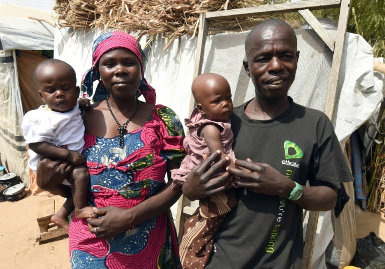 Bitrus Yakubu and his wife Maryam, an internally displaced couple, stand beside their tent holding their seven-month-old twins Grace and Sidi at the Internally Displaced Persons Camp in Maiduguri, on February 4, 2016