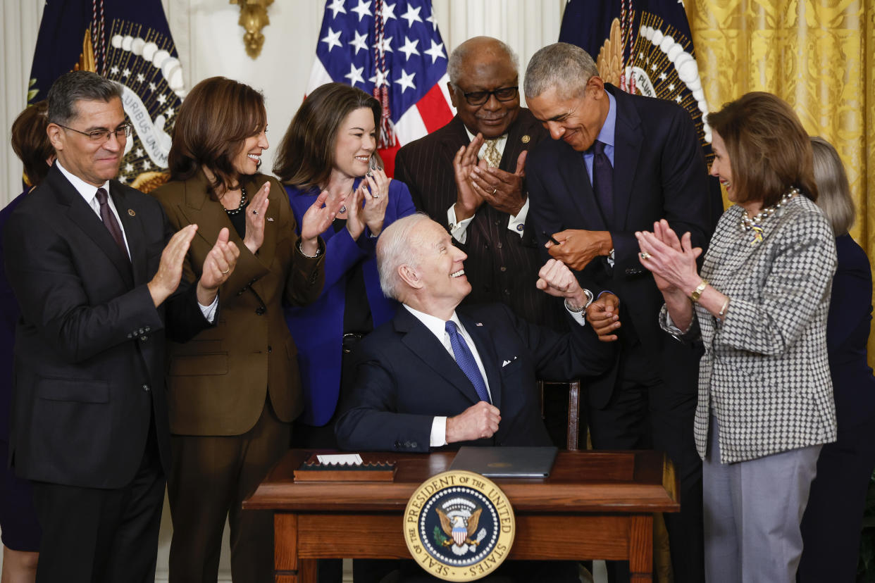 President Biden fist-bumps Obama after Biden signed an executive order aimed at strengthening the ACA during an event to mark the bill's 2010 passage on Tuesday. House Speaker Nancy Pelosi is at right. 