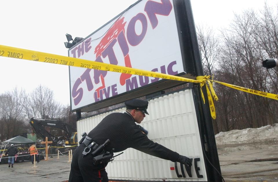 A West Warwick police officer removes the lettering from The Station marquee on a day that families of the victims visit the site in West Warwick,