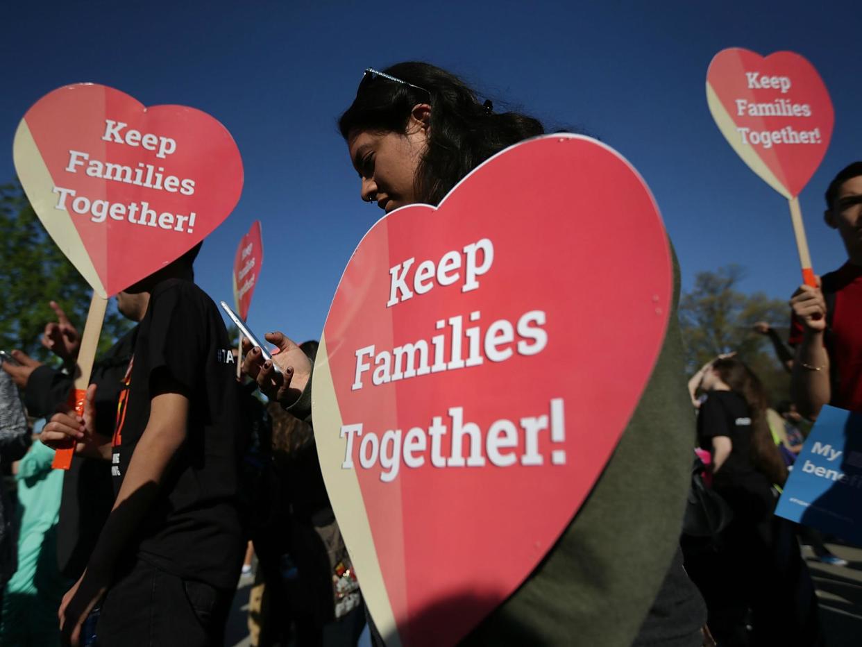 Pro-immigration activists hold signs as they gather in front of the US Supreme Court on 18 April 2016 in Washington, DC: Alex Wong/Getty Images