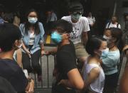 Pro-democracy students in front of a fence blocking an entrance to a carpark receive a copy of a court injunction offered by a representative of an office tower off a road blocked by protesters outside the government office, after they refused to leave, in Hong Kong October 21, 2014. REUTERS/Bobby Yip