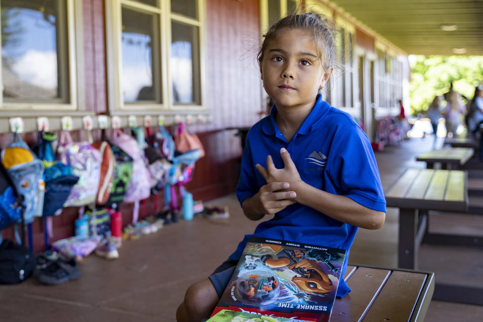Maui Preparatory Academy student Zane Chambliss Alexander talks with the head of school, Dr. Miguel Solis, about the book he chose from a book fair on Tuesday, Oct. 3, 2023, in Lahaina, Hawaii. (AP Photo/Mengshin Lin)
