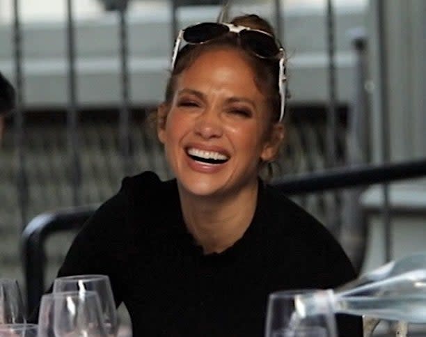 Jennifer gives a big smile while sitting at a dinner table