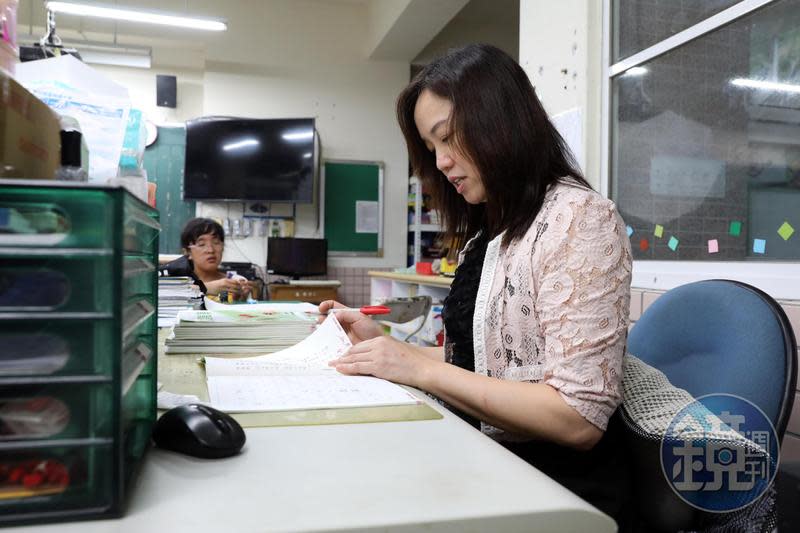 放學後，沈雅琪（右）仍在教室改作業，她的女兒在一旁陪伴，等爸爸來接她。