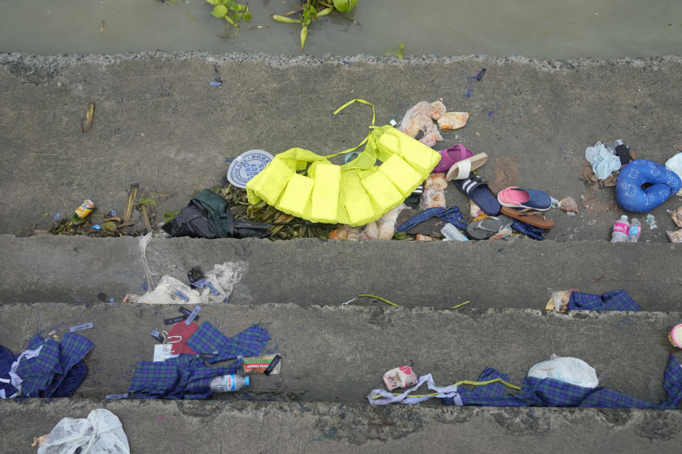 Items belonging to passengers of a capsized boat lie along the stairs of the Kalinawan port as search and rescue efforts continue in Binangonan, Rizal province, Philippines on Friday, July 28, 2023. A Philippine passenger boat carrying dozens of people, including children, overturned Thursday after being lashed by strong wind in a town southeast of Manila and search and rescue efforts were underway, the Coast Guard said. (AP Photo/Aaron Favila)