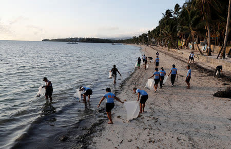 Policemen collect trash at Bulabog beach in the holiday island of Boracay during the first day of a temporary closure for tourists, in Philippines April 26, 2018. REUTERS/Erik De Castro